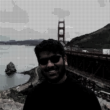 Kelvin DeCosta wearing sunglasses and a black hoodie, smiling in front of the Golden Gate Bridge on a cloudy day.